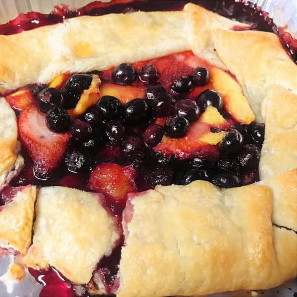 Grilled peach and berry pie with golden crust on a baking tray from Chef Rays LLC.