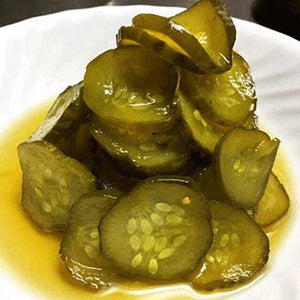 Sliced pickles on a white plate, gourmet barbecue-inspired side dish