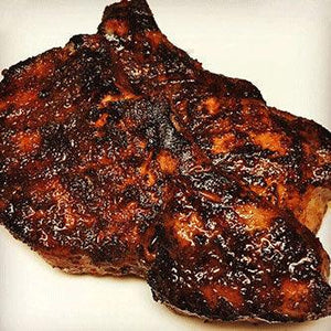 Juicy grilled pork chop with rich barbecue glaze on a white plate, Chef Ray Sheehan style.