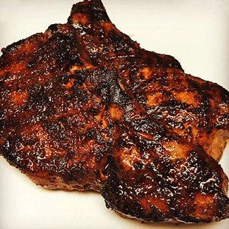 Juicy grilled pork chop with rich barbecue glaze on a white plate, Chef Ray Sheehan style.