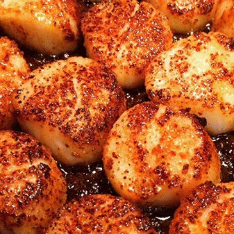 Close-up of seared sea scallops with golden-brown crust, perfect for grilling inspiration