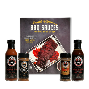 A BBQ sauce gift set featuring a cookbook titled 'Award-Winning BBQ SAUCES AND HOW TO USE THEM' alongside four bottles and jars of Chef Ray Sheehan's Barbecue Sauce and rubs on a transparent background.