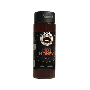 A 12 oz bottle of Chef Ray Sheehan's Hot Honey sauce, featuring a dark brown body, a black cap, and a black label with orange and white text.