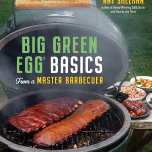 Big Green Egg Basics cookbook cover with BBQ ribs on grill and side dishes outdoors, Chef Ray Sheehan.