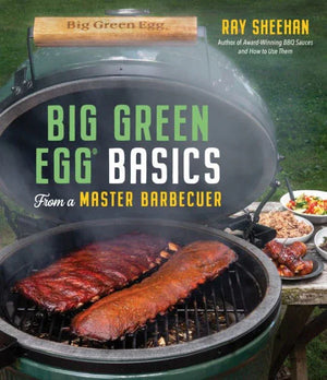 Big Green Egg Basics cookbook cover with BBQ ribs on grill and side dishes outdoors, Chef Ray Sheehan.